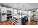 Bright, updated kitchen with stainless steel appliances, white cabinets, an island with seating, and hardwood floors at 16270 Northwind Ct, Westfield, IN 46074