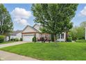 Charming brick and siding home features a well-manicured lawn and a two-car garage at 1663 Sweetgum Dr, Greenwood, IN 46143