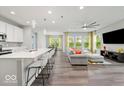 Open-concept living space with modern lighting, hardwood floors, and a comfortable sofa at 16739 Cattle Hollow Ln, Noblesville, IN 46060