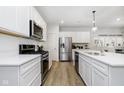 Galley style kitchen featuring white cabinets, stainless appliances, and light wood floors at 18763 Moray St, Westfield, IN 46074
