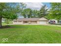 Inviting single-story home with a green lawn, mature trees, and a swing hanging from a large tree at 212 W Banta Rd, Indianapolis, IN 46217