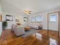 Bright living room with polished hardwood floors, ceiling fan, and stylish furniture at 2399 E Mckay Rd, Shelbyville, IN 46176