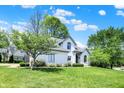 A well-maintained front exterior of a suburban home with a spacious green lawn and mature trees at 3162 Hazel Foster Dr, Carmel, IN 46033