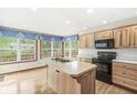 Sunlit kitchen features an island, wood cabinets, and a scenic view at 320 Thornberry Dr, Carmel, IN 46032