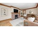 Comfortable living room with a brick fireplace, hardwood floors, and a plush brown sectional at 329 W Hampton Dr, Indianapolis, IN 46208