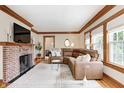 Bright living room featuring a brick fireplace, hardwood floors, and a cozy brown sectional couch at 329 W Hampton Dr, Indianapolis, IN 46208