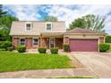 Attractive brick home with tan siding and a cozy covered porch, complemented by well-maintained landscaping at 3505 Autumn Ct, Columbus, IN 47203