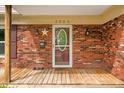 Close-up of a charming brick front porch featuring a decorative star, a mailbox, and inviting light fixtures at 3505 Autumn Ct, Columbus, IN 47203