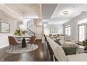 Spacious living room featuring an open-concept design, hardwood floors, a modern dining area, and a black-iron staircase at 355 E Ohio St # 314, Indianapolis, IN 46204