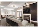Modern living room featuring hardwood floors, stylish furniture, fireplace, and a TV above the mantel and access to the balcony at 355 E Ohio St # 314, Indianapolis, IN 46204