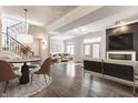 Open-concept living room with hardwood floors, modern furniture, and a dining area with decorative lighting and black-iron staircase at 355 E Ohio St # 314, Indianapolis, IN 46204