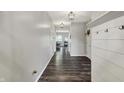 Long hallway featuring wood floors, a coat rack, and pendant lights at 4032 Stubbington Ln, Indianapolis, IN 46239