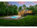 A dusk view of the backyard, with its inviting pool and manicured lawn at 4128 Whitetail Woods Dr, Bargersville, IN 46106