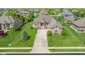 Aerial view of a beautiful home with manicured lawn and landscaping in a suburban neighborhood at 4890 Benthaven E Dr, Bargersville, IN 46106