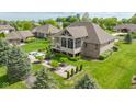 Aerial view of a backyard with a hot tub, patio, fireplace, screen porch, and manicured landscaping at 4890 Benthaven E Dr, Bargersville, IN 46106