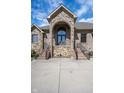 Close up of the arched stone entrance, featuring double doors and a concrete driveway with stairs at 4890 Benthaven E Dr, Bargersville, IN 46106