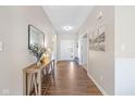 Bright foyer with wood floors features a console table and a view of the front door and hallway at 5375 Citadel Dr, Noblesville, IN 46062