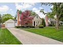 Charming stone and vinyl home featuring a large driveway and a detached garage at 5439 Indianola Ave, Indianapolis, IN 46220