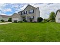 Well-maintained two-story home with a lush green lawn, lovely landscaping, and an attached two-car garage at 5507 Wakefield Rd, Greenwood, IN 46142