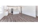 Bright kitchen features stainless appliances, white cabinets and island, and wood grain floors at 5784 Summertree Pl, Whitestown, IN 46052