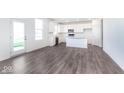 Bright kitchen features stainless appliances, white cabinets and island, and wood grain floors at 5784 Summertree Pl, Whitestown, IN 46052