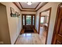Home entryway with hardwood flooring, coat rack and a view of the dining room at 5851 Beisinger Pl, Indianapolis, IN 46237