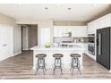 Modern kitchen with stainless appliances, a large island with seating, white cabinetry, and a stylish backsplash at 588 Bluestem Ln, New Whiteland, IN 46184