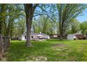 Expansive backyard featuring a spacious deck area, mature trees, and storage shed at 6673 Karyn Dr, Avon, IN 46123