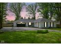 Charming single-story home featuring a two-car garage and well-manicured front lawn at dusk at 6673 Karyn Dr, Avon, IN 46123