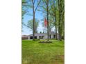 Beautifully landscaped front yard with mature trees and an American flag in the center at 6673 Karyn Dr, Avon, IN 46123