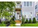 Inviting front entrance with wood porch, stylish door and manicured landscaping at 952 Elm St, Indianapolis, IN 46203