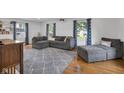 Bright living room with hardwood floors, gray sectional, and blue accent curtains at 9860 Sunnymeade Ln, Indianapolis, IN 46280