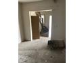 View of a living room space with torn up carpet and entrance to staircase at 1014 W 33Rd St, Indianapolis, IN 46208