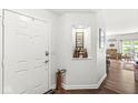 Inviting entryway featuring white door and walls, wood floors and decoratively placed curios at 10143 Winslow Way, Fishers, IN 46037