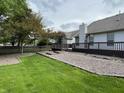 Expansive backyard with a wooden deck, gravel area, and green grass, partially fenced at 10305 Lakeland Dr, Fishers, IN 46037