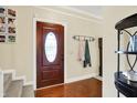 Cozy entryway featuring hardwood floors, a decorative front door with glass, and coat rack on the wall at 10310 Foxwood W Dr, Carmel, IN 46280