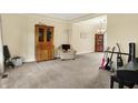Spacious living room with neutral carpet, large cabinets, a comfortable chair, and views into dining area at 10310 Foxwood W Dr, Carmel, IN 46280