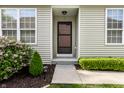 A welcoming front entrance with a screen door, sidelight windows, and manicured landscaping at 1041 Lincoln Park E Dr, Greenwood, IN 46142