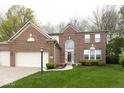 Beautiful brick home with a three-car garage, arched entryway, and neatly landscaped front yard at 12253 Bedrock Ct, Fishers, IN 46037