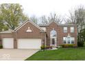 Lovely brick home featuring an attached three-car garage, mature landscaping, and welcoming entrance at 12253 Bedrock Ct, Fishers, IN 46037