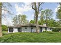 Angle view of a brick ranch with an attached two-car garage and well-manicured lawn at 13765 Howe Rd, Fishers, IN 46038