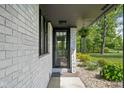 Inviting front entrance with a decorative welcome sign, landscaped garden and a black frame door at 13765 Howe Rd, Fishers, IN 46038