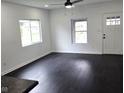 Bright and airy living room featuring updated dark hardwood floors, large windows, and white walls at 1545 Finley Ave, Indianapolis, IN 46203