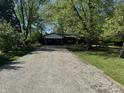 View of the home from the driveway surrounded by lush greenery at 1725 E 100 S, Lebanon, IN 46052