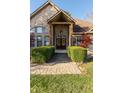 Covered entryway featuring a brick walkway and manicured hedges leading to double front doors at 1832 Live Oak Ct, Avon, IN 46123
