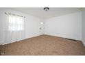 Bright living room featuring neutral carpet, white walls, and a large window with natural light at 1912 Broadway St, Anderson, IN 46012