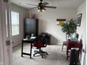 Cozy home office featuring a ceiling fan, black desk, and a comfortable red office chair at 230 Kiawah Dr, Whiteland, IN 46184