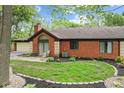 Backyard view of a brick home with a manicured lawn and charming patio at 2922 Amherst St, Indianapolis, IN 46268