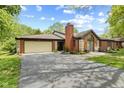 Brick home with a two-car garage, large driveway, and well-maintained landscaping at 2922 Amherst St, Indianapolis, IN 46268