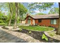 Lovely brick home featuring mature trees, decorative landscaping, and a welcoming entrance at 2922 Amherst St, Indianapolis, IN 46268